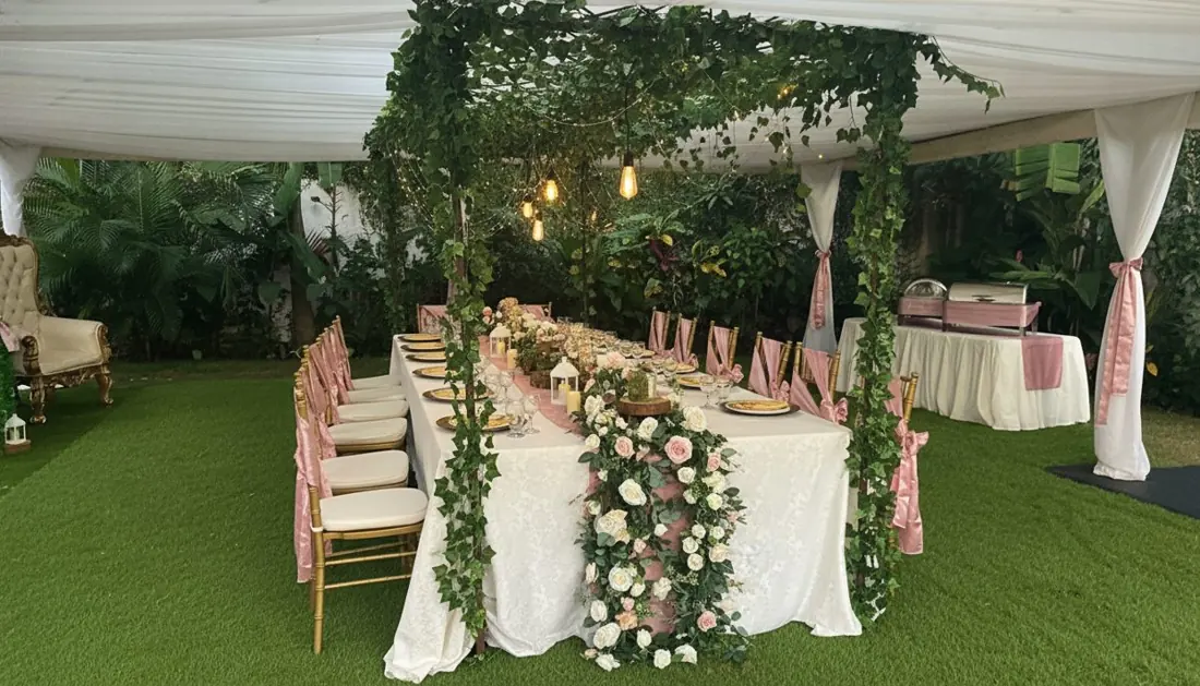 Mesa imperial bajo carpa en el jardín con arco de enredaderas