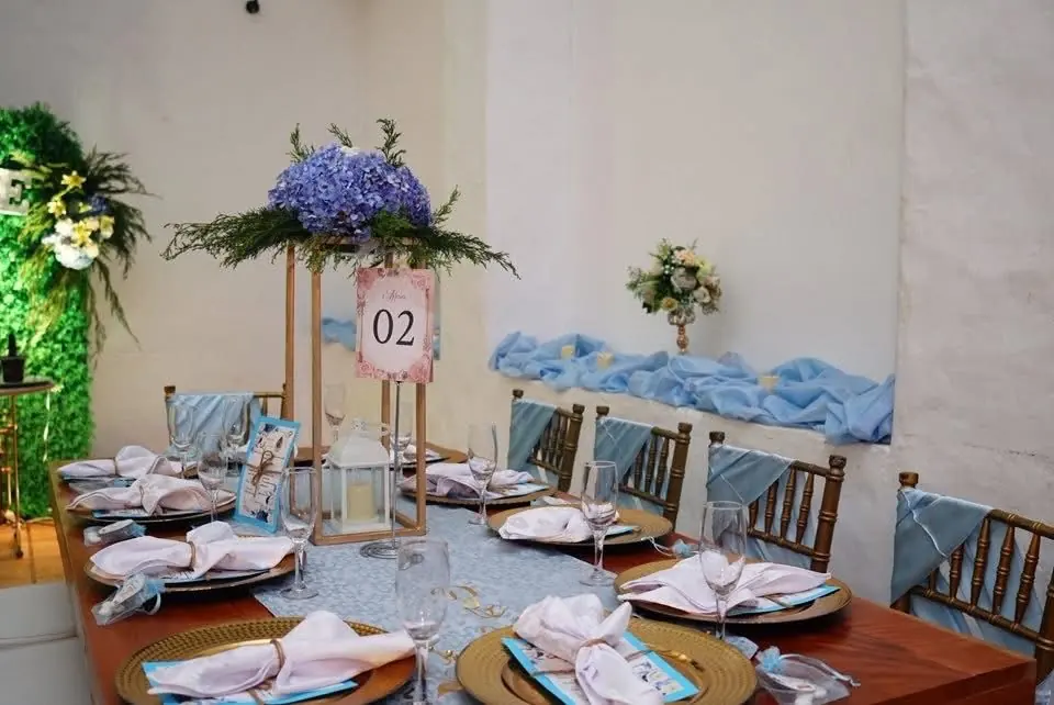 Mesa con centro de hortensias azules y número de mesa