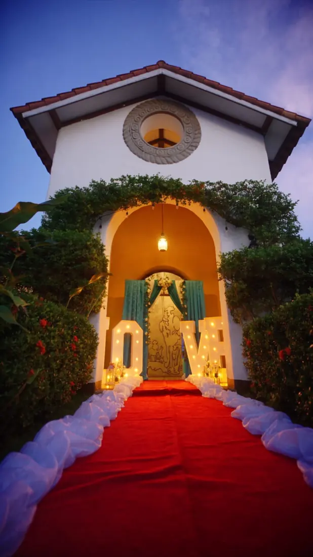 Entrada colonial con alfombra roja y letras LOVE iluminadas